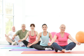 Fototapeta premium Group of people practicing yoga in gym