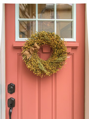 Colorful door with dried wreath on vintage home © Kristen
