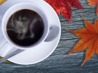 Coffee on timber and maple leaves in orange