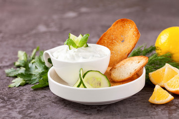Tzatziki sauce in a  sauce-boat. Ingredients for a dzadziki. Turkish dish cacik. Selective focus. Copy space
