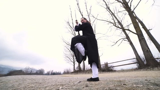 Martial arts sword fighter stand on one leg low angle view 4K