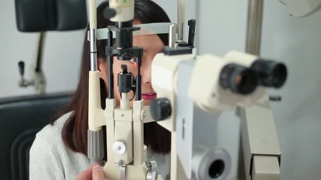 Patient with head in medical device for examining for eye sight