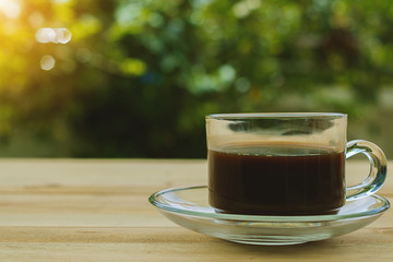 A cup of coffee on blurred green natural background with vintage retro color