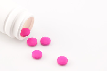 pink pills pouring out of the bottle