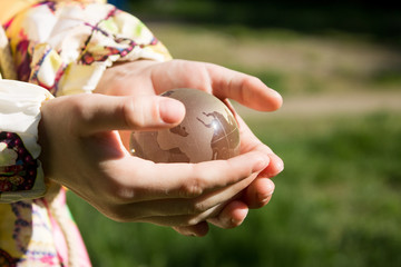 Crystal globe in children's palms