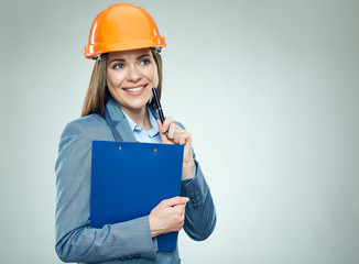 Thinking business woman builder holding  clipboard with contract.