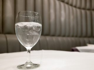 Tall glass fill by water and ice put on whit surface table in resturant