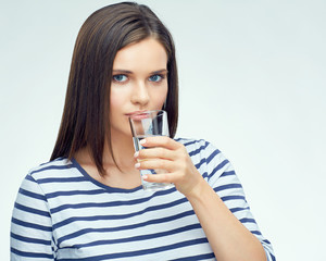 Beautiful girl with long hair drinking water from glass.