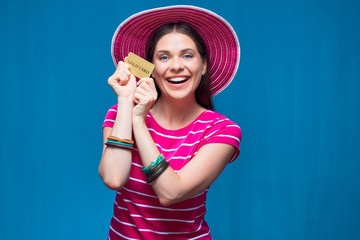 Smiling woman wearing beach hat posing with credir card