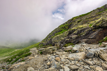 Fototapeta na wymiar Steep slope on rocky hillside in fog