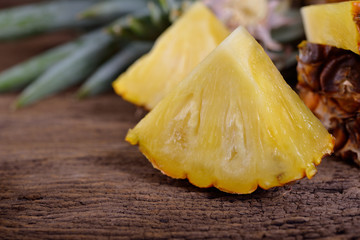 portion cut ripe pineapple on wooden table