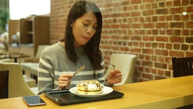Woman having cake inside coffee shop