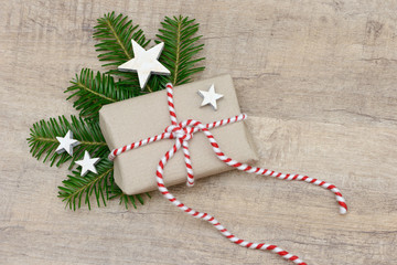 xmas present with fir branch and star lying on wood