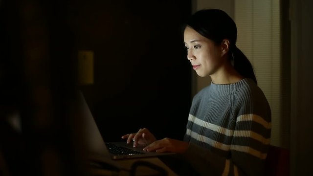 Woman using laptop computer at night