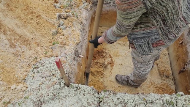 Archeology: removal of the next layer on the bottom of the excavation using a shovel