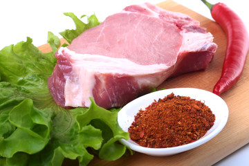 Raw pork chops with herbs and spices on cutting board. Ready for cooking.