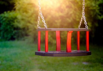 Old vintage wooden red teeter in sunset light