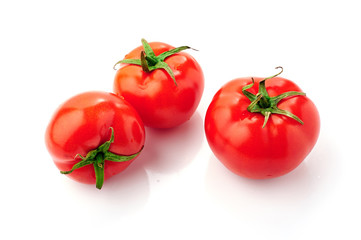 Three red ripe tomatoes with water drops isolated on white background. Top view.
