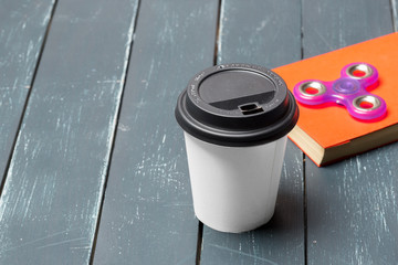 Workplace with coffee cup, spinner and book