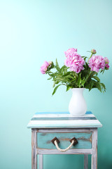 Bouquet of peony flowers in vase on mint background