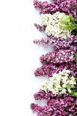 Branch of lilac flowers on white wooden table