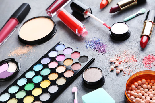 Different makeup cosmetics on grey wooden table