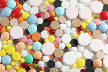 Different colorful pills on white background