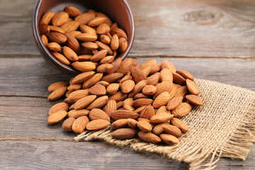 Almonds in bowl on wooden table