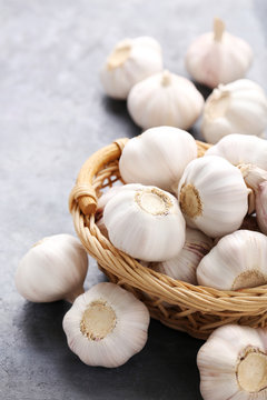 Garlic in basket on grey wooden table