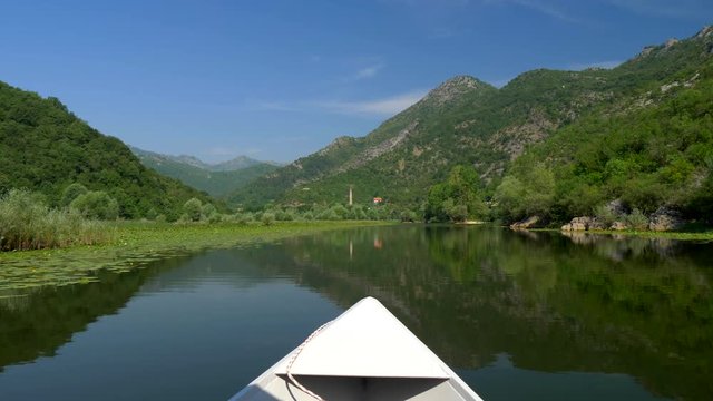Boat trip at Rijeka Crnojevica river in Montenegro. Excursion boat sails on green canyon of Rijeka Crnojevica in Skadar Lake National Park