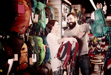 Fototapeta na wymiar Man and woman discussing the purchase of rucksacks