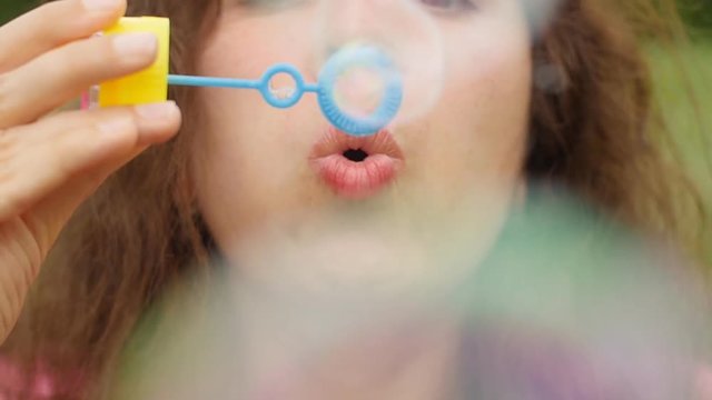 Woman blowing soap bubbles at sunset
