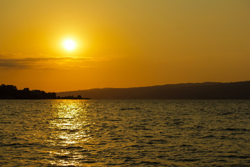 A view of a golden sunset over the sea. The light of the sun reflected in the water as the beam path.