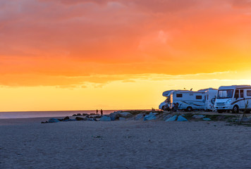 Motor homes, camper vans at sunset beach.Travel adventure vacation.