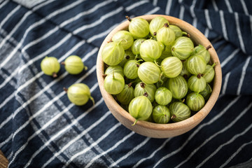 Fresh gooseberry in a wooden bowl.