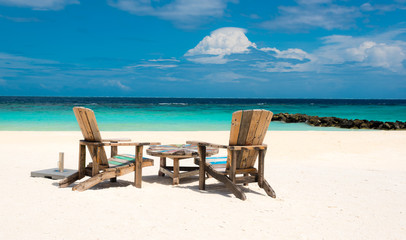 wooden chairs on a tropical beach