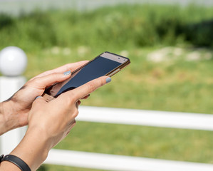 hand of a girl holds a mobile phone with a black screen. Empty space for promotional message