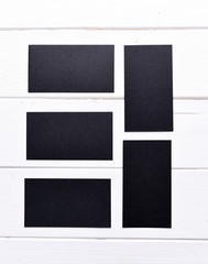 Fototapeta na wymiar set of black business cards on a white wooden table, top view