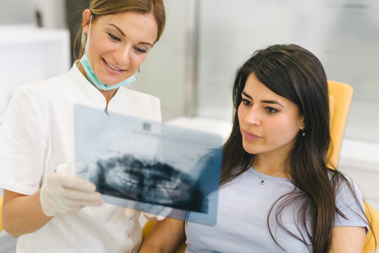 Dentist and patient looking at dental x-ray