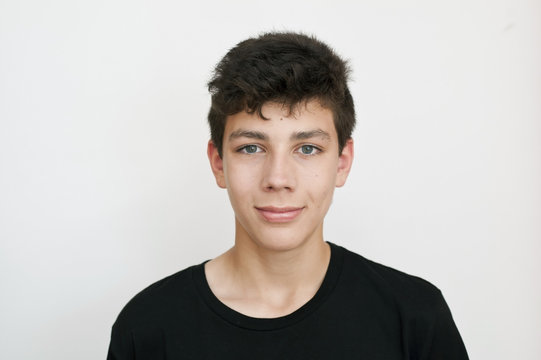 A teenager in a black T-shirt stands. On a white background