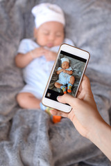 Mom is taking baby photos with a smartphone.