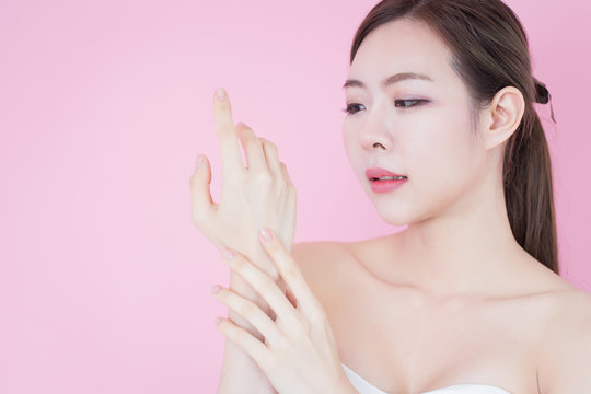 Portrait of young beautiful asian woman touch her clean fresh skin face. cosmetology, skincare, cleaning face, plastic surgery and SPA therapy concept on pink background