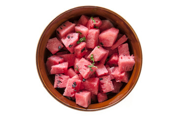 Fresh diced watermelon with mint in bowl isolated on a white background. 