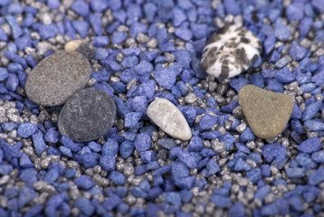 Kiesel auf blauem Sand