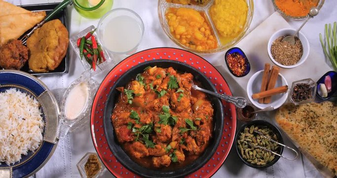Dolly top down zoom out view of a delicious chicken tikka masala with Indian spices