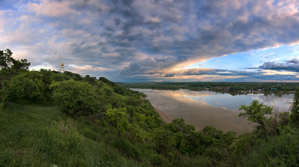 Evening thunderstorm over a wide river.