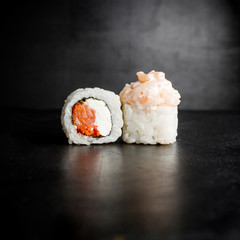 Sushi rolls with salmon isolated on black background.