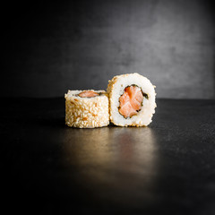 Delicious sushi rolls with fish isolated on black background. Japanese food