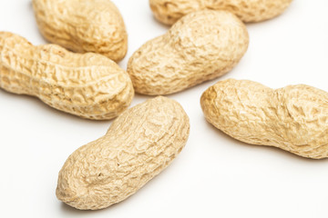 Cacahuetes con cáscaras sobre fondo blanco aislado. Vista superior y cerca