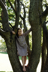 5 years old girl standing by a tree